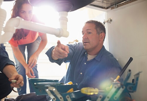 Image depicting a typical kitchen sink plumbing setup, showcasing faucets and pipes.